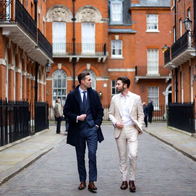 Two dapper gay men walking through a historic street in London, UK.